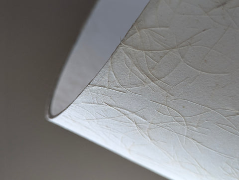close up of the edge detail of a paper lamp shade with textured surface
