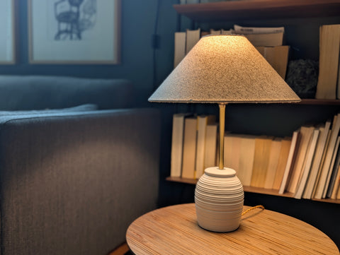 Lamp on a wooden table with books in the background