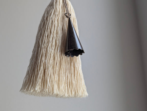 furniture tassel with a dark brown scalloped bell on a gray background