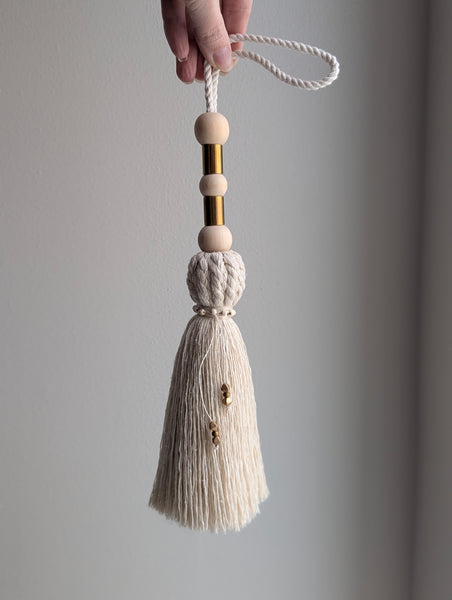 Decorative tassel with wooden beads and a plain background