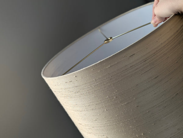 Close-up of a hand holding a lampshade made of silk
