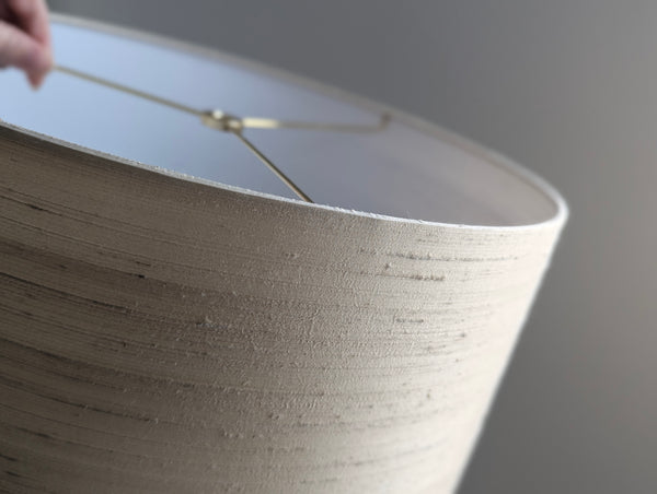 Close-up of a textured silk lampshade with a blurred background