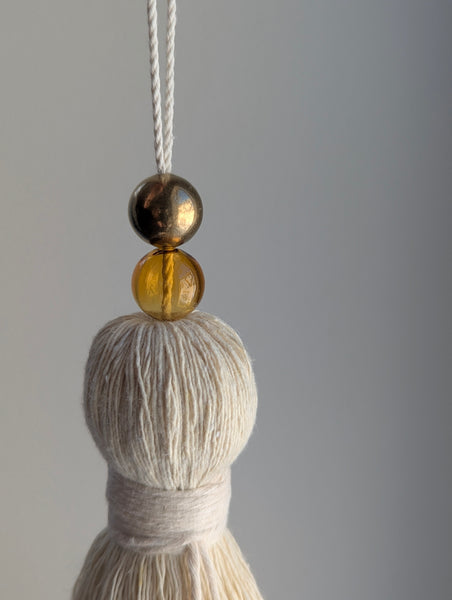 Tassel with two beads on a gray background