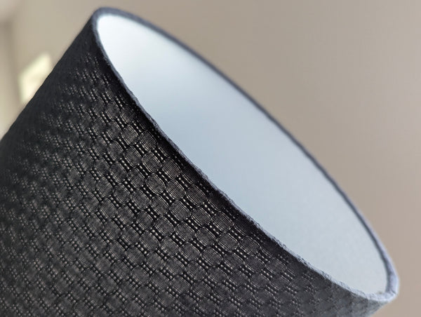 Close-up of a textured gray lamp shade with a blurred background