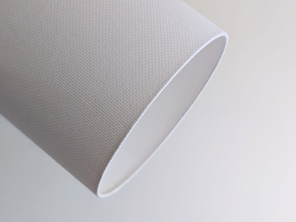 Close-up of a white textured lampshade in Bright White Crosshatch fabric against a soft gray background