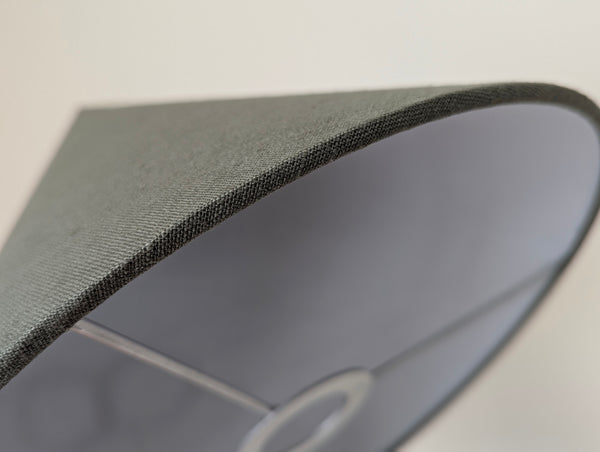 close up edge detail of the cone lamp shade in olive green linen with nickel hardware