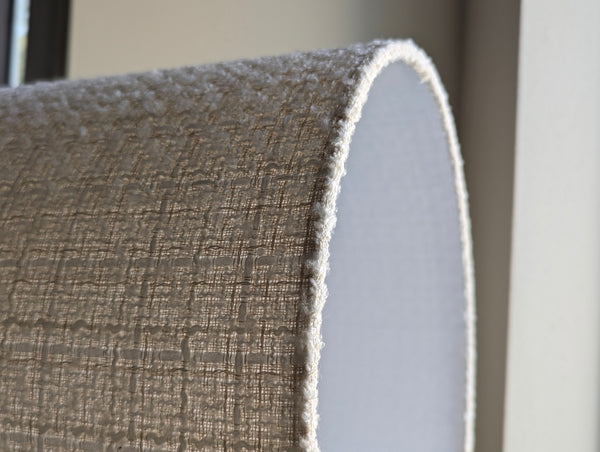Close-up of a textured boucle lamp shade with sunlight shining through it