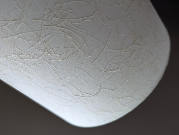 close up of a mulberry paper lamp shade with strong texture and cream color
