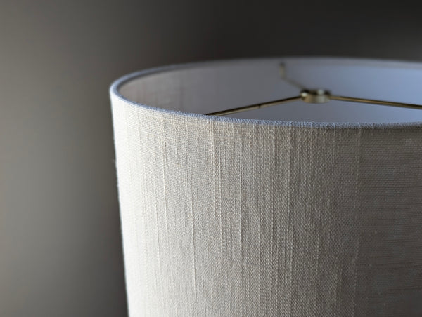 Close-up of a drum lampshade made of white linen fabric with spider washer hardware