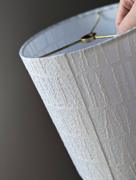 Close-up of the back seam of a textured white lampshade with a geometric pattern