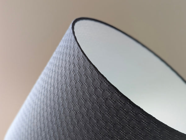 Close-up of a textured gray lamp shade with a blurred background