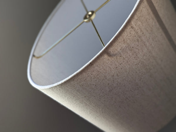 close up of an oval lamp shade with natural cotton fabric