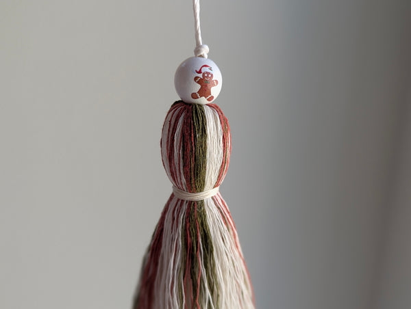 holiday tassel gift tag in red and green with a gingerbread man bead at the top