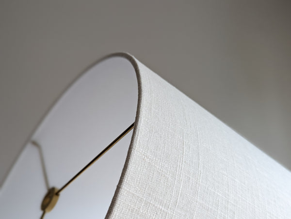 Close-up of a drum lampshade made of white linen fabric with spider washer hardware