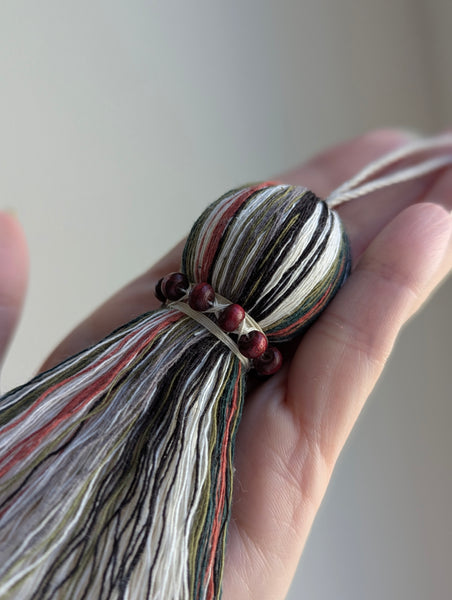 red and green seasonal tassel door hanger with cranberry red wooden beads