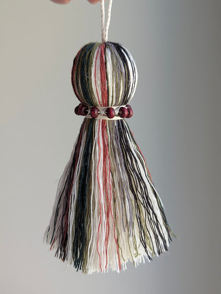 red and green seasonal tassel door hanger with cranberry red wooden beads