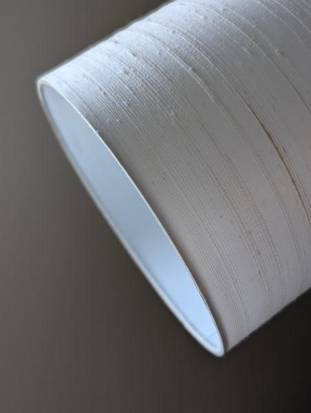 close up of a white silk lampshade against a dark background