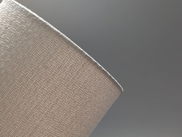 mid-mod boucle fabric lamp shade close up with spider washer hardware