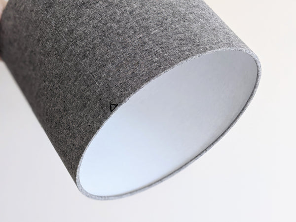 back and white woven fabric lampshade with a black triangle stitch detail on the back seam on a neutral background