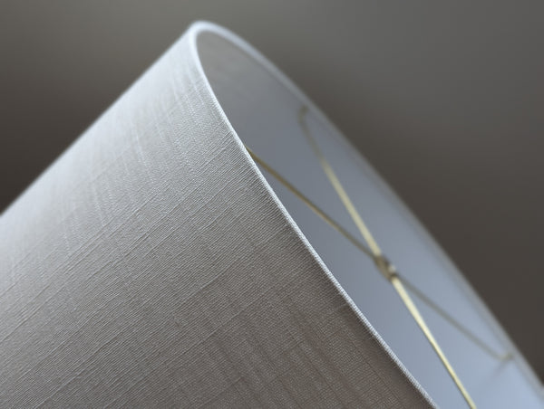 Close-up of a drum lampshade made of white linen fabric with spider washer hardware