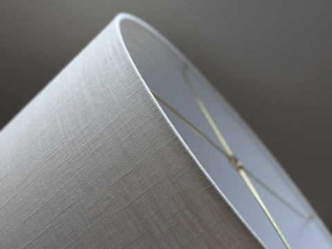 Close-up of a drum lampshade made of white linen fabric with spider washer hardware