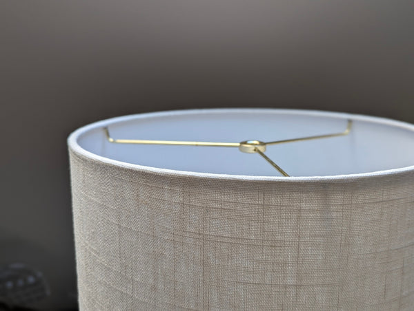 Close-up of a drum lampshade made of white linen fabric with spider washer hardware