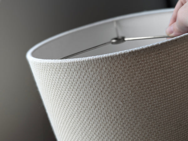 Close-up of a textured fabric lampshade in natural crosshatch fabric with nickel spider hardware