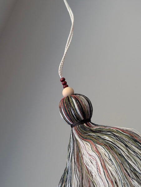 red and green seasonal tassel door hanger with cranberry red wooden beads