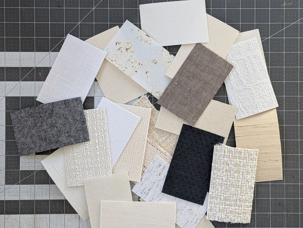 Collection of fabric lamp shade swatches in various colors and textures on a grid background