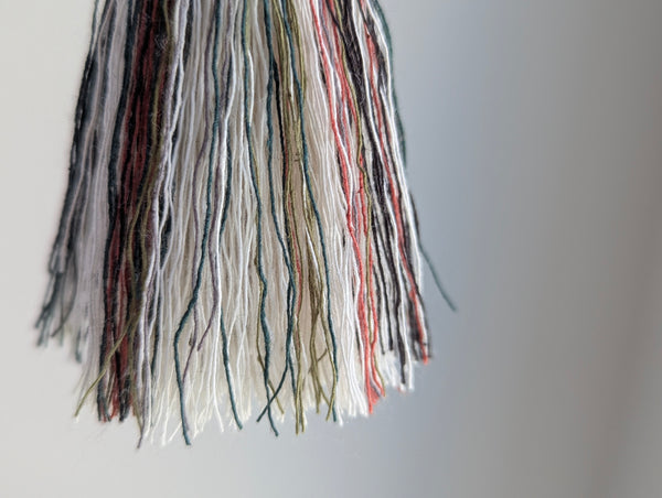 red and green fringe detail on holiday tassel ornament