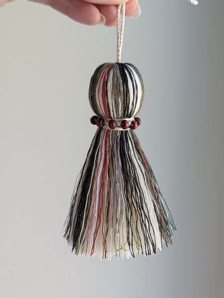 red and green seasonal tassel door hanger with cranberry red wooden beads