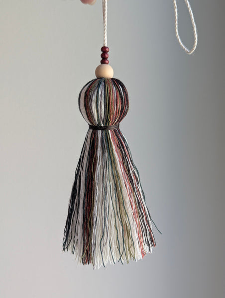 black, green, and red seasonal tassel door hanger with cranberry red wooden beads