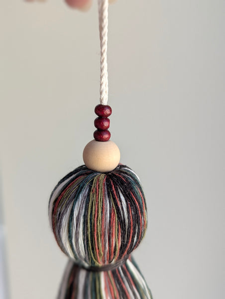 black, green, and red holiday tassel door hanger with cranberry red wooden beads