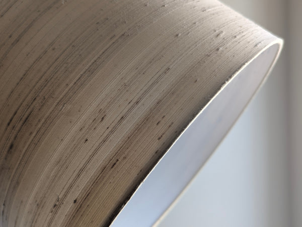 Close-up of a textured lamp shade with a white background