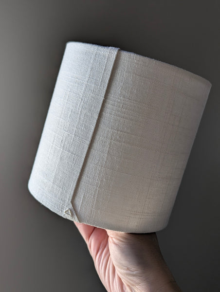 Close-up of a small lampshade made of white linen fabric