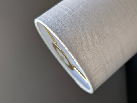 Close-up of a drum lampshade made of white linen fabric with euro fitter hardware