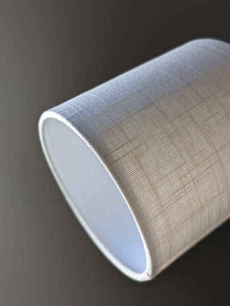 Close-up of a small drum lampshade made of white linen fabric 