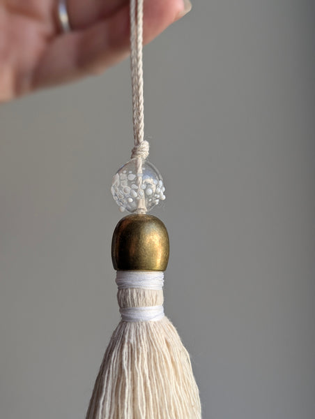 snowy white snowflake tassel with white speckled glass bead and brass snowflake charm
