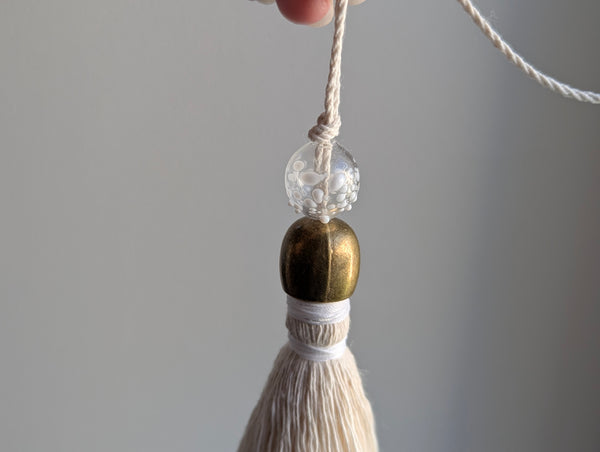 snowy white snowflake tassel with white speckled glass bead and brass snowflake charm