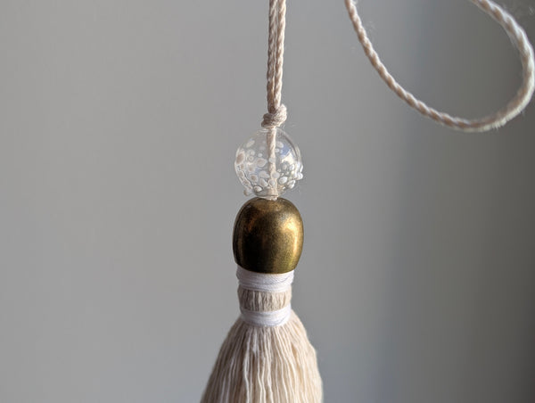 snowy white snowflake tassel with white speckled glass bead and brass snowflake charm