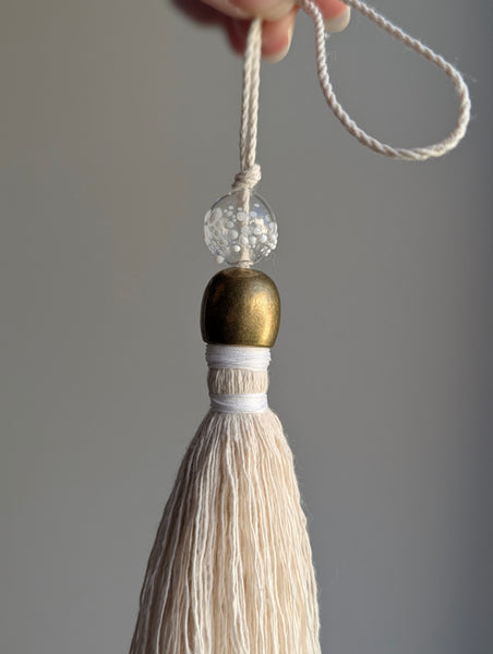 snowy white snowflake tassel with white speckled glass bead and brass snowflake charm
