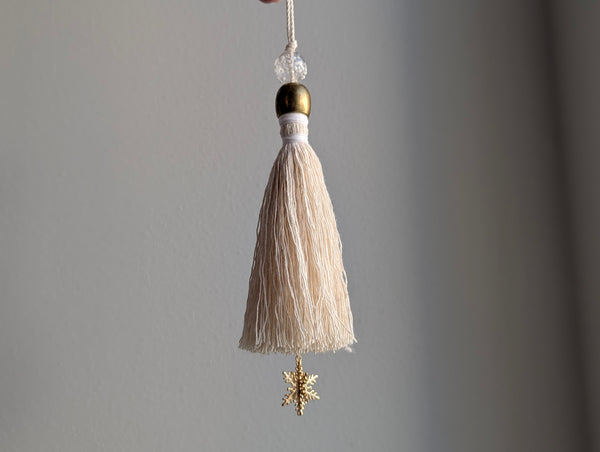 snowy white snowflake tassel with white speckled glass bead and brass snowflake charm