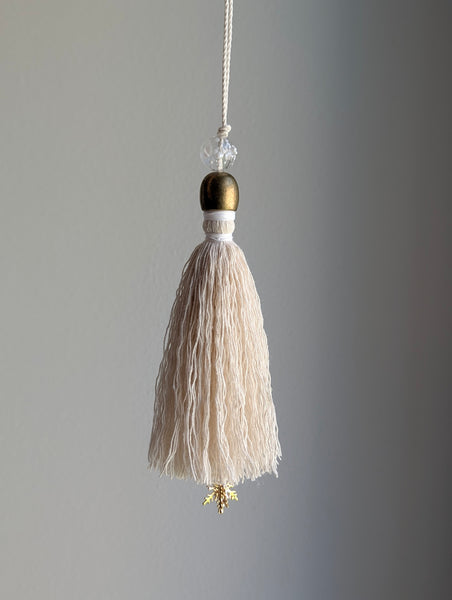 snowy white snowflake tassel with white speckled glass bead and brass snowflake charm