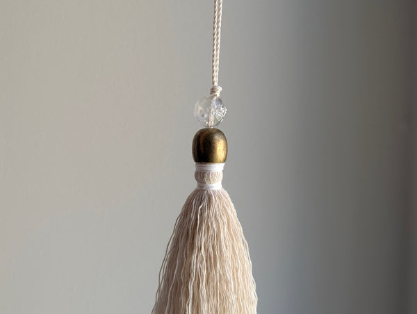 snowy white snowflake tassel with white speckled glass bead and brass snowflake charm