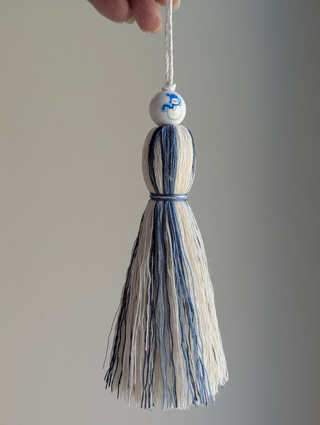 holiday tassel gift tag in blue and white with a snowman bead at the top