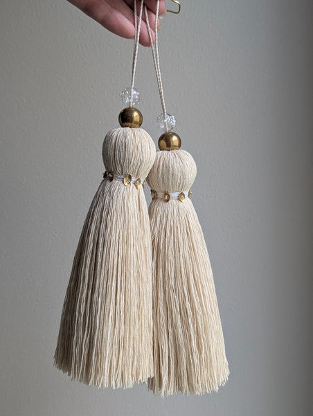 snowy white tassel in a natural cotton color with brass accents and a handblown glass bead