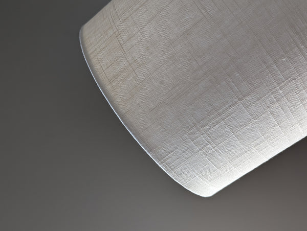 Close-up of a drum lampshade made of white linen fabric
