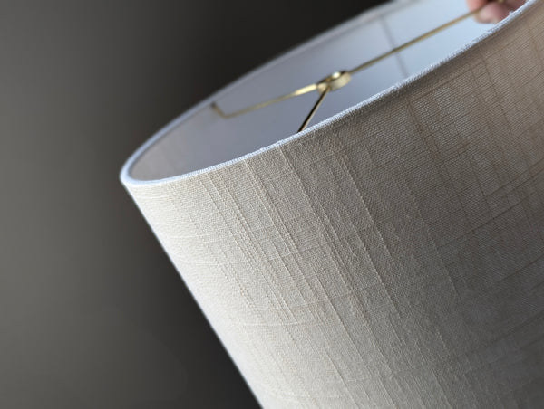 Close-up of a drum lampshade made of white linen fabric with spider washer hardware