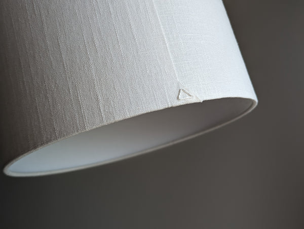 Close-up of the back seam of a drum lampshade made of white linen fabric