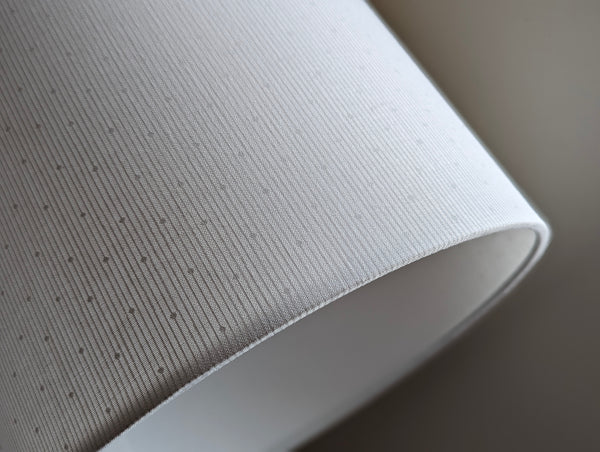close up of white striped lamp shade with polka dots